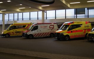 Kolme ambulanssia parkissa.