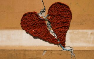 Keskeltä halkaistu sydänkuvio, joka on virkattu punaisesta langasta